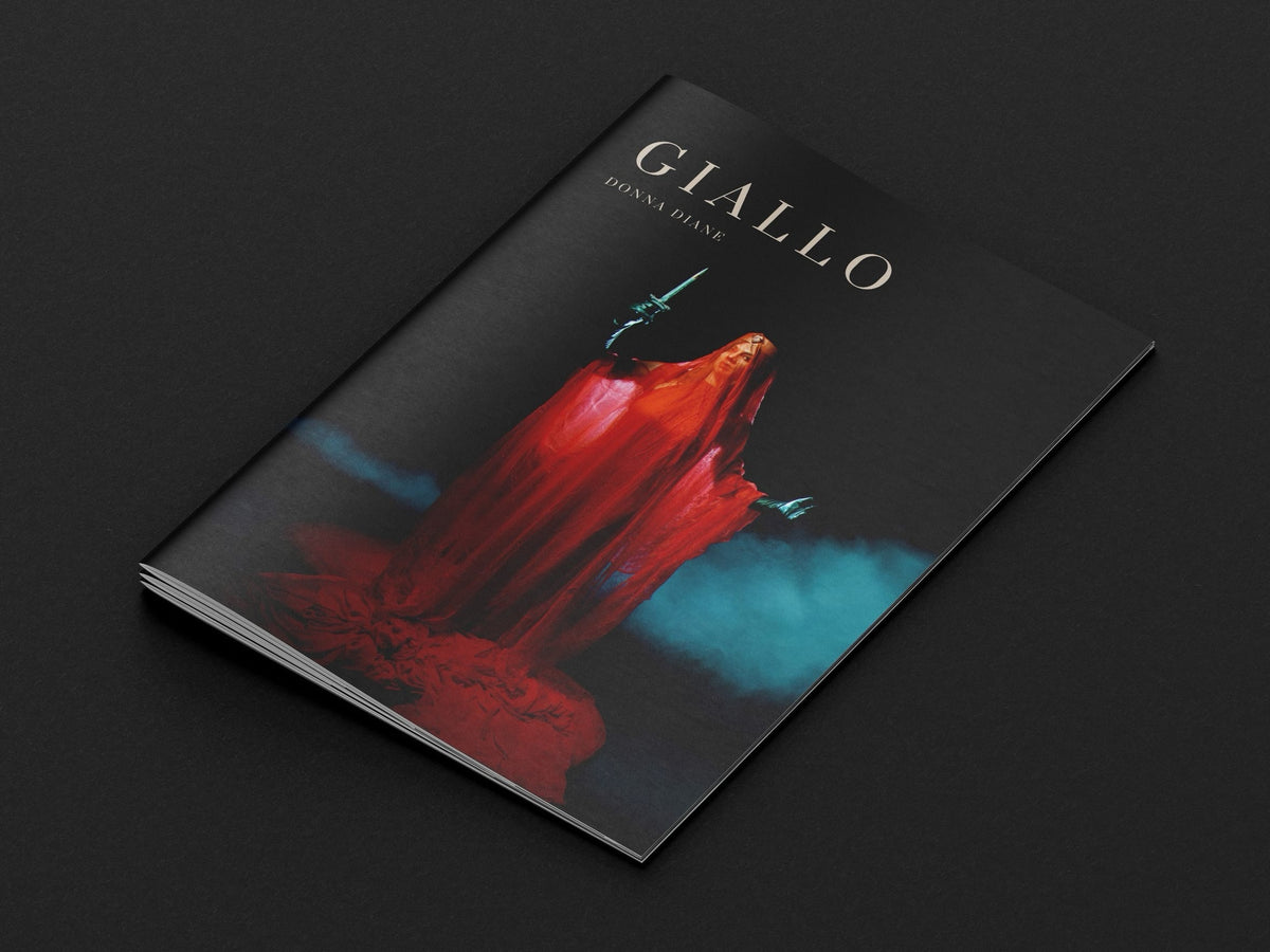 A book titled Giallo by Donna Diane, featuring a cover with a figure in a flowing red robe holding a dagger against a dark, moody blue background.
