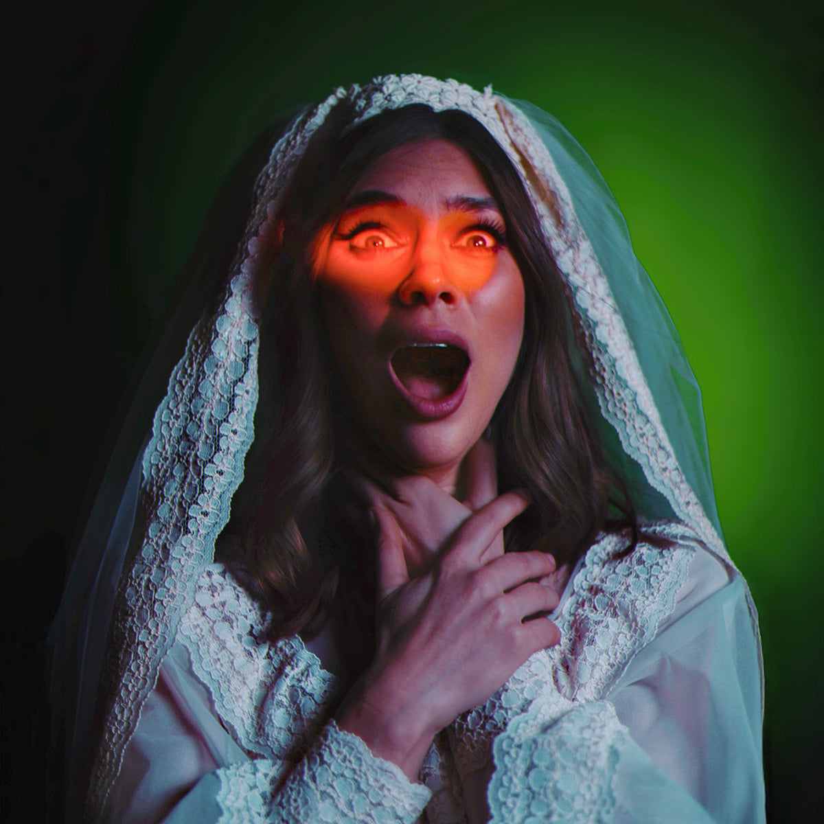 Djunah in a white lace bridal veil and gown with a shocked expression, lit by a dramatic red eyelight and green theatrical lighting against a dark background.